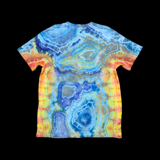 Back of the tie dye tee showing concentric blue and navy geode rings framed by yellow, orange, and red edges.