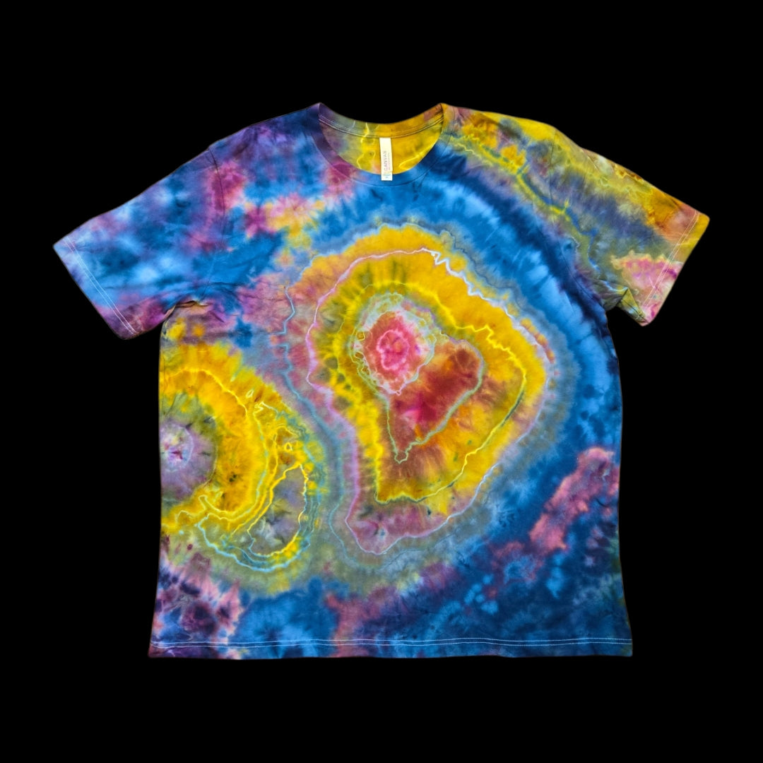 Front of a tie-dyed t-shirt with a geode ice dye pattern of yellow, pink, and blue concentric rings.