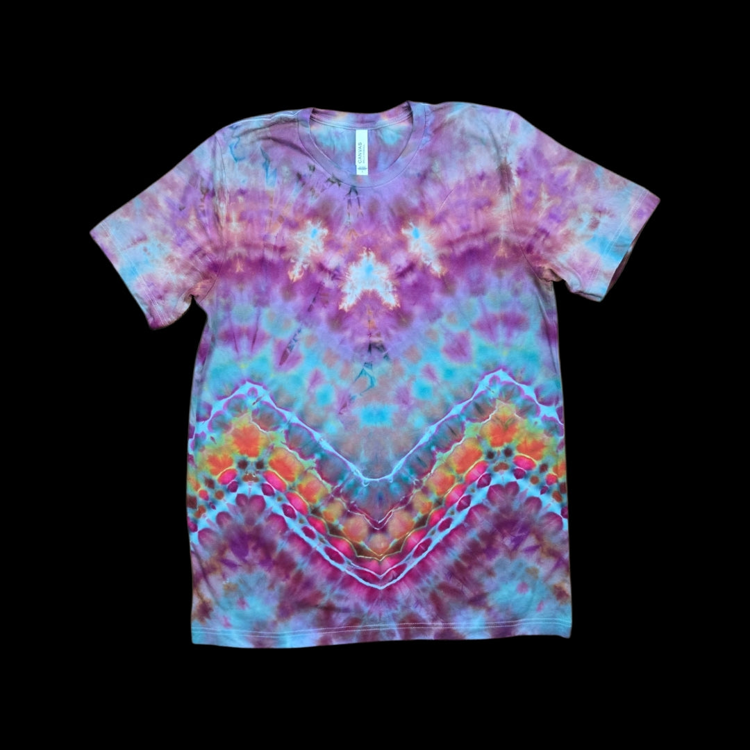 Front of a tie-dyed t-shirt with a chevron geode pattern in purple, teal, pink, orange, and yellow with white bands.