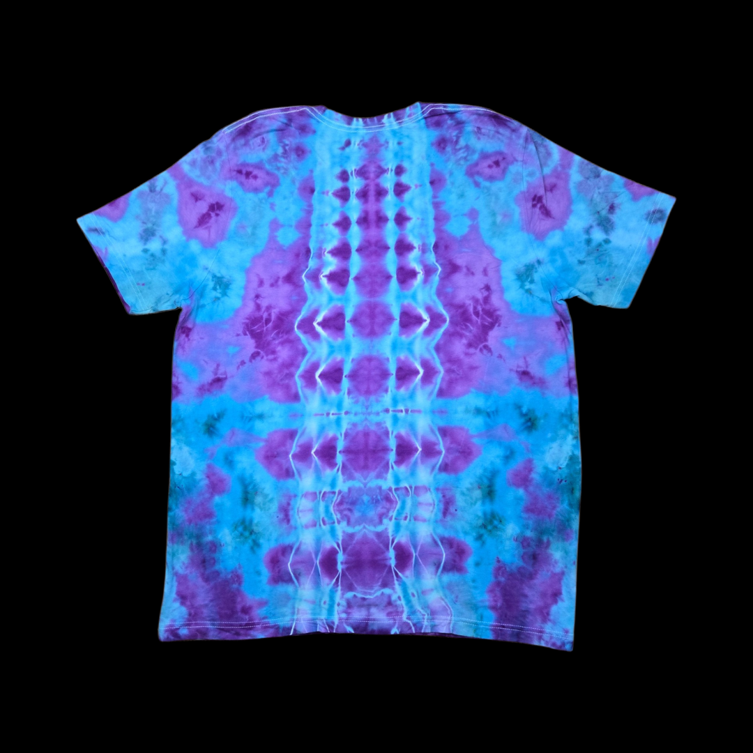 Back of the tie-dye tee showing a mirrored purple, blue, and green spine fold pattern down the center.