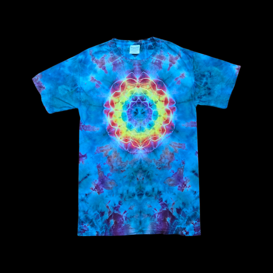 Front of a blue and purple ice-dyed tee with a rainbow mandala of yellow, red, and teal rings on the chest.