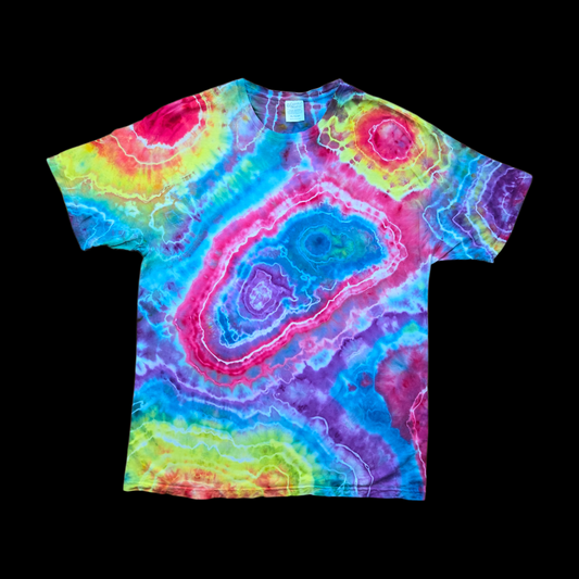 Front of a rainbow tie-dye t-shirt with a large geode swirl pattern in pink, blue, purple, and yellow on a black background.