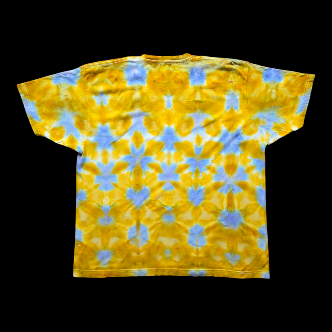 Back of the same tee showing the mirrored triangle shibori pattern in gold, yellow, and light blue.