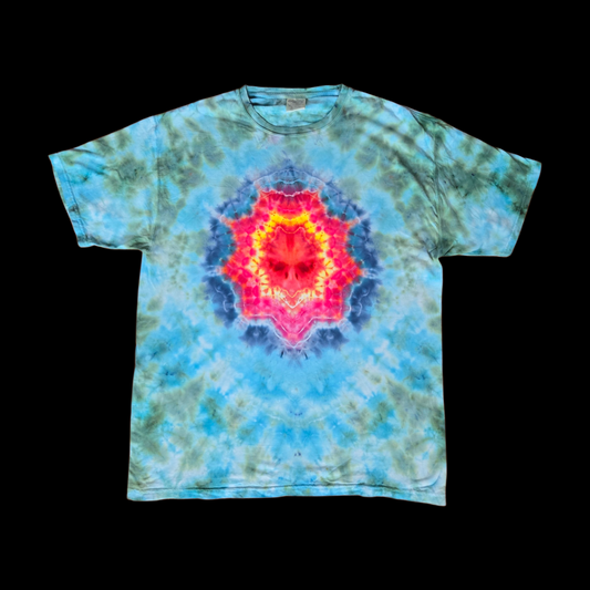 Front of a tie-dye tee with a centered mandala in red, pink, orange, and yellow ringed by navy blue on a turquoise and olive-green mottled background.