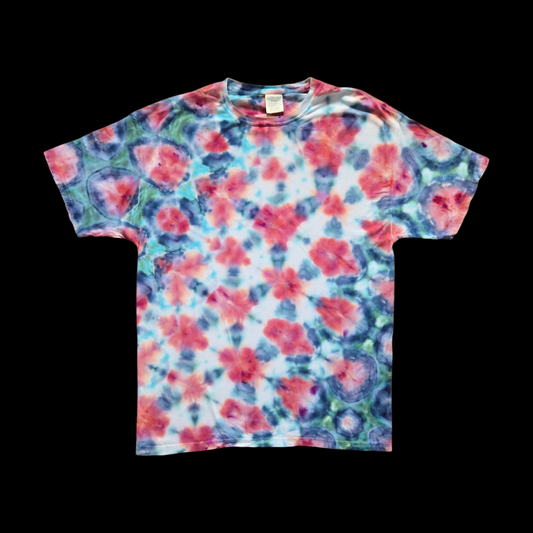 Front of an XL tee with an allover shibori-inspired pattern of red and pink rounded shapes ringed by navy and teal on a white ground.