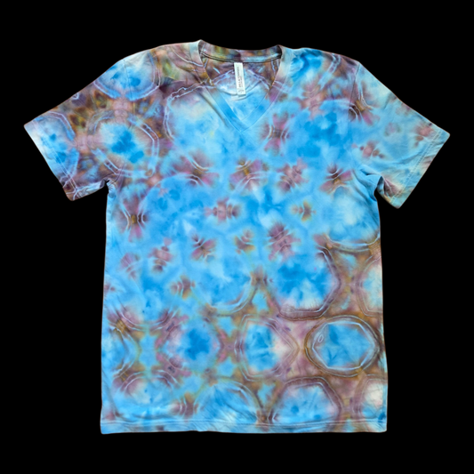 Front of a blue, mauve, and brown shibori tie-dye v-neck t-shirt on a black background.