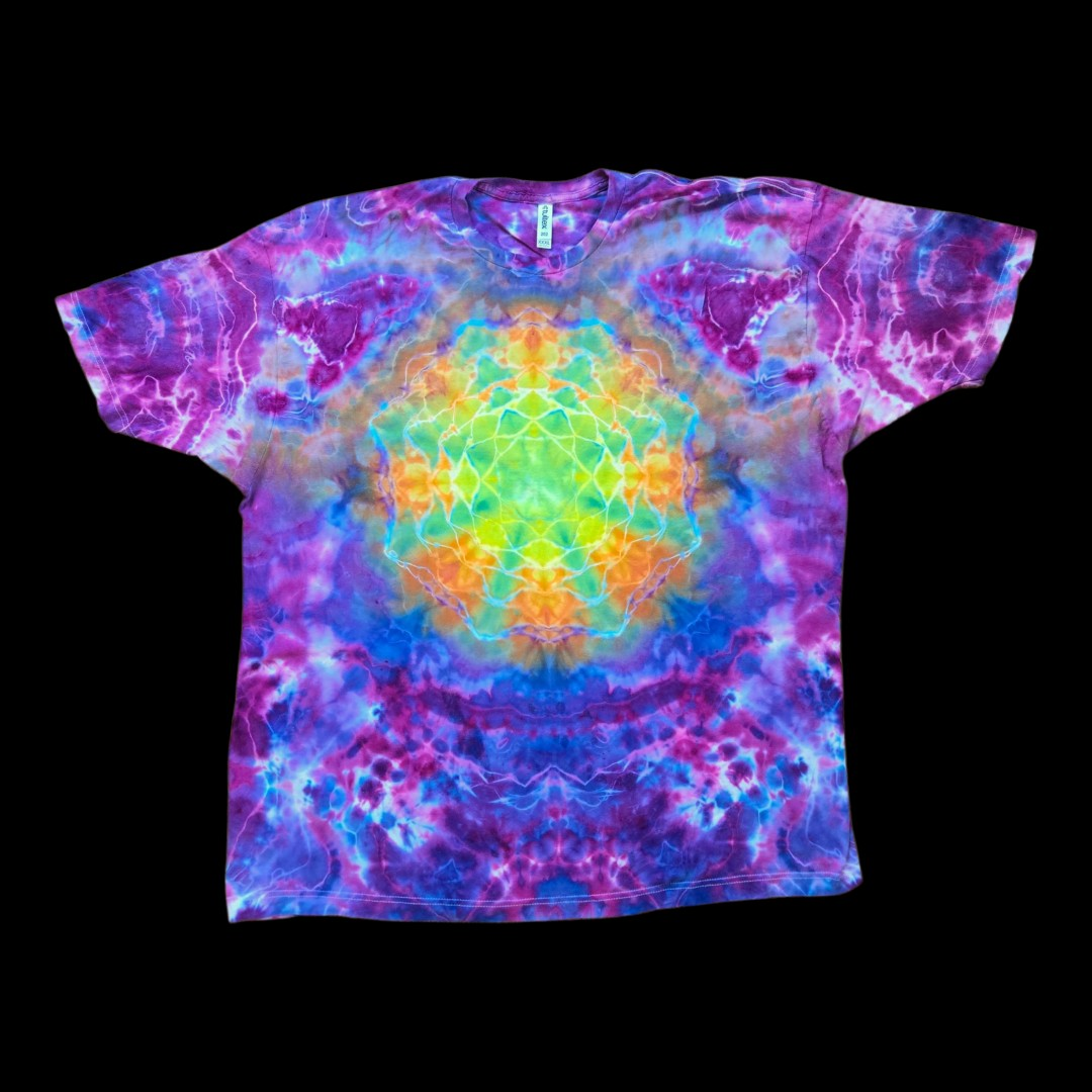 Front of a 3XL tie dye t-shirt with a rainbow ice dye mandala of yellow, green, orange, and teal at the chest surrounded by purple, magenta, and blue.