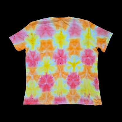 Back of the same tee showing the repeating triangle-fold grid in pink, orange, and yellow with white and pale blue-white edges.
