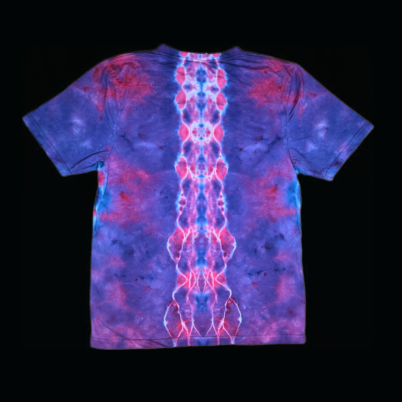 Back of the tie-dye tee showing a symmetrical blue and pink spine pattern down the center over purple.