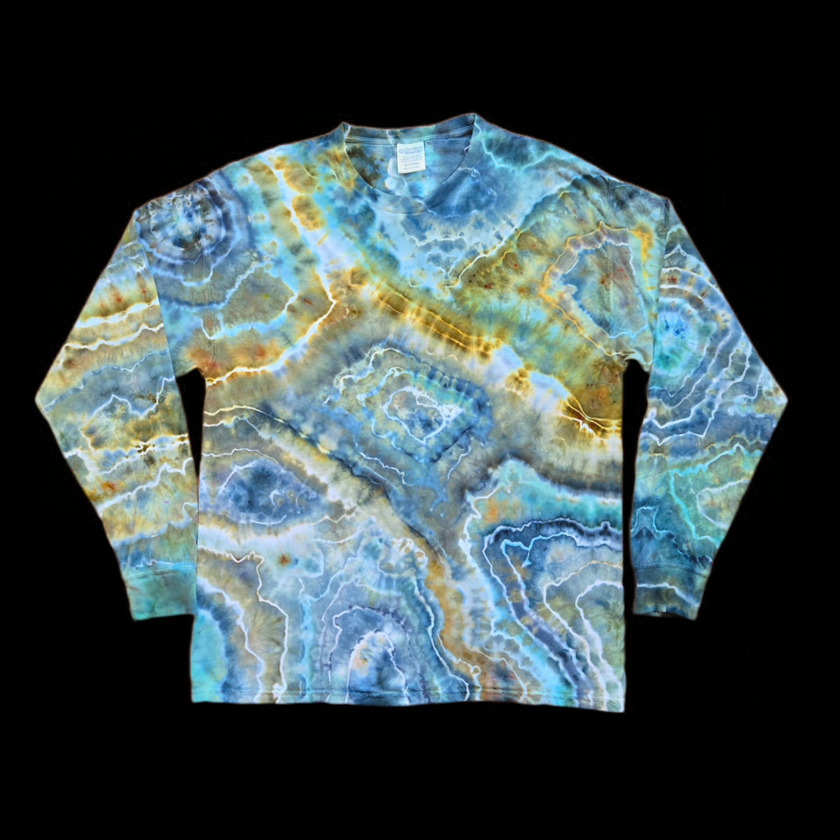 Front of a long sleeve tie dye shirt with an allover ice dye geode pattern of concentric rings and veins in blue, slate gray, teal, gold, and tan outlined by white lines.